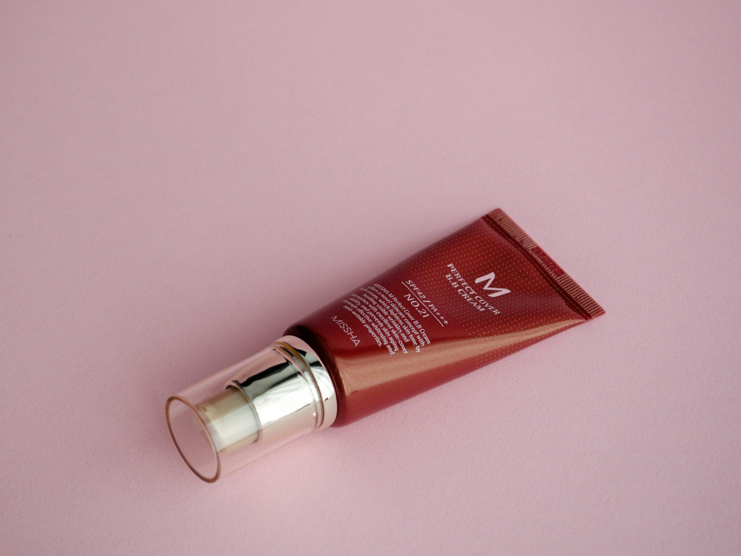 Close-up of a cosmetic tube on a pink surface, perfect for skincare and beauty themes.